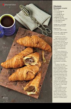 an image of croissants on a cutting board next to a cup of coffee