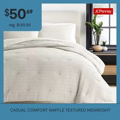 a bed with white comforter and pillows on it for $ 50 99 reg $ 300 00