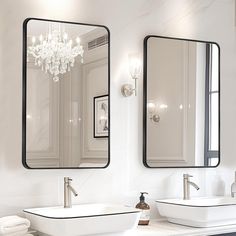 two sinks and mirrors in a white bathroom