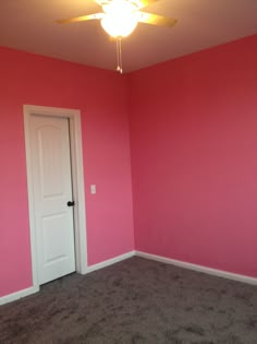 an empty room with pink walls and carpet