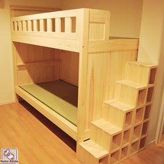 a wooden bunk bed sitting on top of a hard wood floor next to a wall