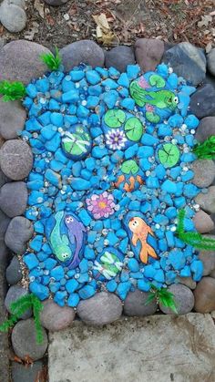 a rock garden with fish and plants painted on it