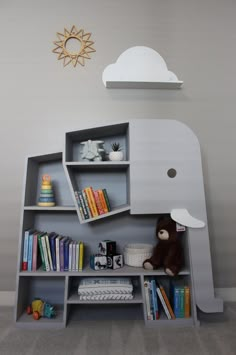 an elephant shaped book shelf with books and toys on it's shelves in a child's room