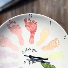 a white clock with handprints on it