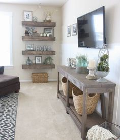 a living room filled with furniture and a flat screen tv mounted above a wooden table