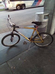 a bicycle parked next to a bus on the street