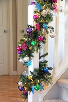 a christmas tree decorated with ornaments on the banister