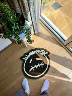 a person standing in front of a door with their feet on the floor next to a rug