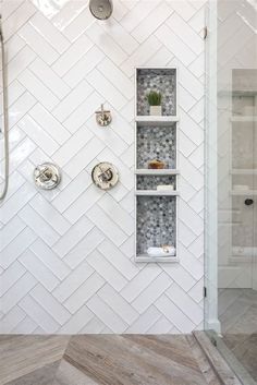 a white tiled shower with shelves on the wall