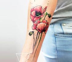 a woman's arm with two red flowers on the left side of her arm