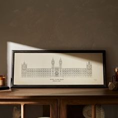 a framed photograph sitting on top of a wooden table next to candles and other items