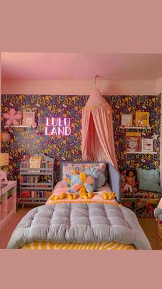 a pink canopy bed sitting in a bedroom next to a book shelf filled with books