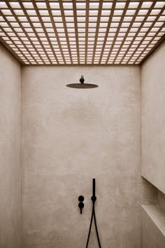 an empty room with a shower head in the corner