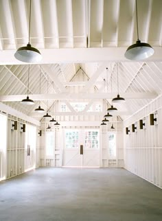 the inside of a large white building with several lights hanging from it's ceiling