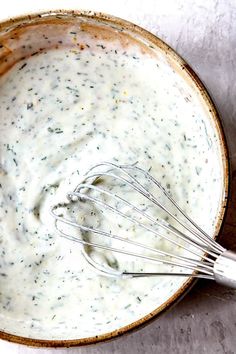 a whisk in a bowl filled with cream sauce