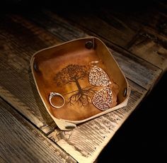 a wooden tray with a tree on it and two rings sitting in the middle of it