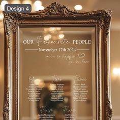 an ornate frame holds a wedding seating plan in front of a mirror with lights on the ceiling