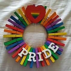 a wreath made out of pops sticks with the word pride spelled in white letters