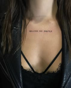 a woman's chest with the words killing me softly tattooed on her left side