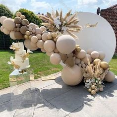 an outdoor area with balloons and flowers on the ground next to a large round object