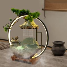 a round table with a potted plant in it and a waterfall coming out of the top