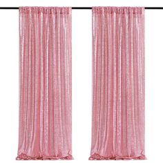 two pink curtains hanging on the side of a window