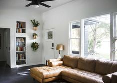 a living room filled with furniture and a ceiling fan