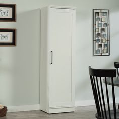 a tall white cabinet sitting next to a dining room table