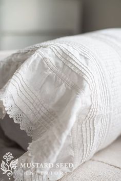 an unmade bed with white linens and lace on the pillow cover is shown in black and white