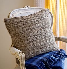 a chair with a knitted pillow on top of it