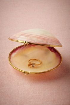 an open shell with a gold ring in it