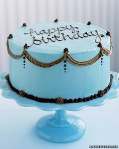 a blue birthday cake with the words happy birthday on it sitting on top of a table