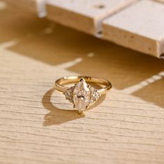 a diamond ring sitting on top of a wooden table next to a piece of wood