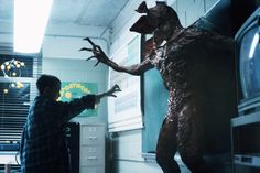 a man standing next to a giant creature in a room