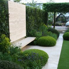 a wooden bench sitting in the middle of a lush green garden