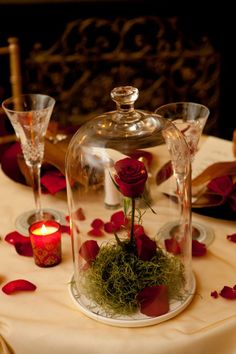 a table topped with a glass dome covered in flowers