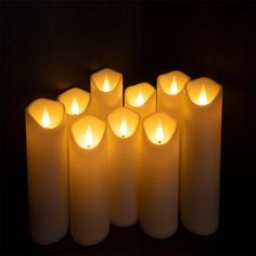 many lit candles are arranged in the shape of an eight - pointed candle, on a dark background