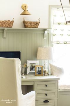 a white chair sitting in front of a desk with a lamp on top of it