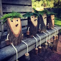 wooden logs with plants growing out of them on a bench in front of some trees