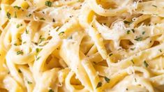 a close up view of pasta with parmesan cheese and herbs on the top