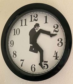 a black and white clock with a man dancing on it