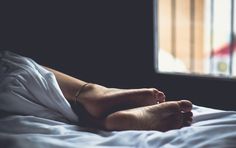 a person's bare feet laying on a bed