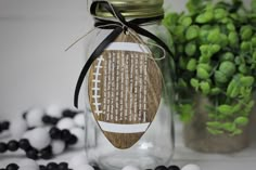 a mason jar filled with black and white candies next to a potted plant