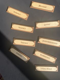 wooden name tags with names on them sitting on top of a black tableclothed surface