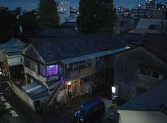 an aerial view of the city at night with buildings and cars parked on the street