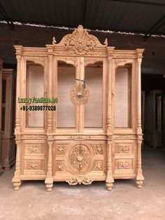 an old wooden cabinet with carvings on the front and sides, in a warehouse area