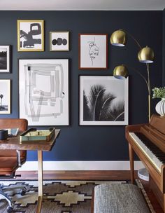 a living room with pictures on the wall and a piano in front of an open window