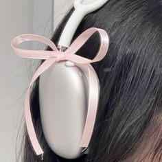 a close up of a person with scissors in their hair and wearing a pink bow