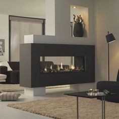 a modern living room with a fireplace in the center