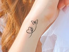 a woman's arm with a tattoo on it that has a butterfly and heart